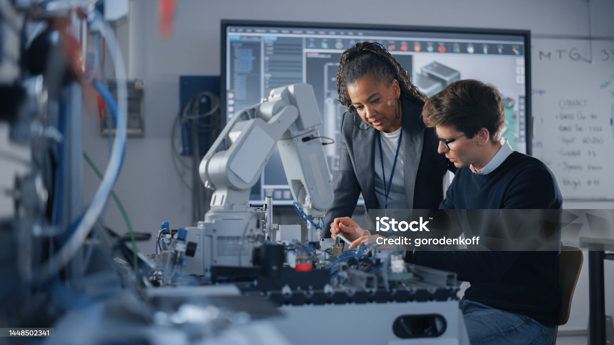 Male Student Engineer Discussing Ideas with Black Teacher while Working with Computer Processor. Man Uses Screwdriver. High-Tech Science and Engineering Concept. Medium Shot